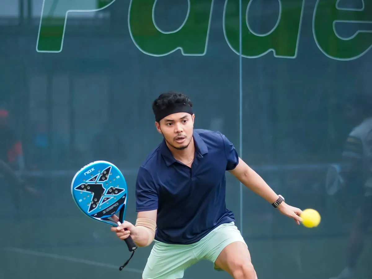 Joueur de padel qui prépare son service, la balle dans la main
